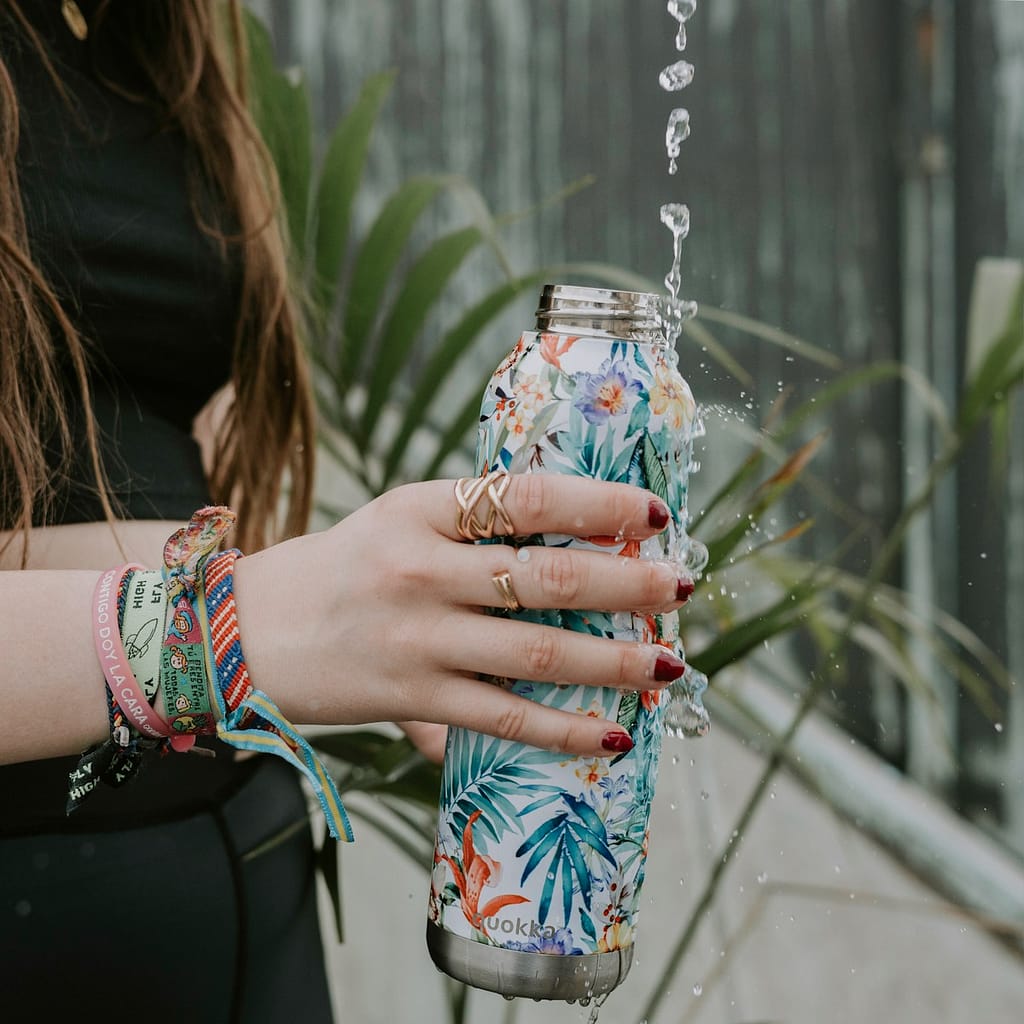 a woman holding a a reusable water bottle