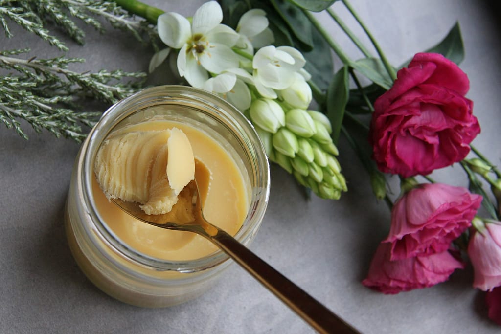jar of shea butter with spoon to make zero waste shave cream