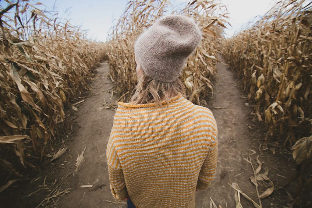 woman standing in brown field while looking sideways utilizing sustainable living choices to easily choose sustainability