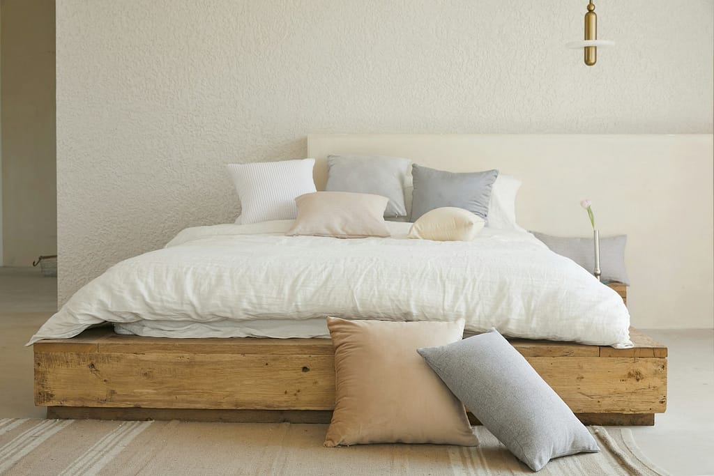 white bed pillow on brown wooden bed frame in home that embraces minimalism