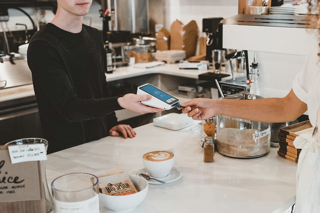 man paying using credit card as he indulges in mindful consumption