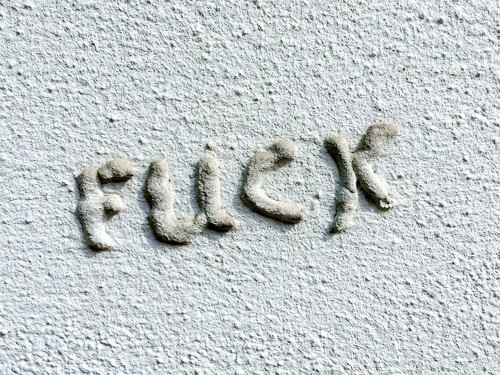raised text with the word FUCK on a white backgroun