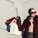 photo of woman holding white and black paper shopping bags