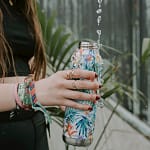 a woman holding a zero waste water bottle in her hand