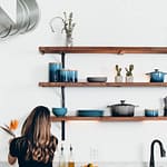 woman standing in front of organized kitchen shelves experiencing the mental health benefits of decluttering