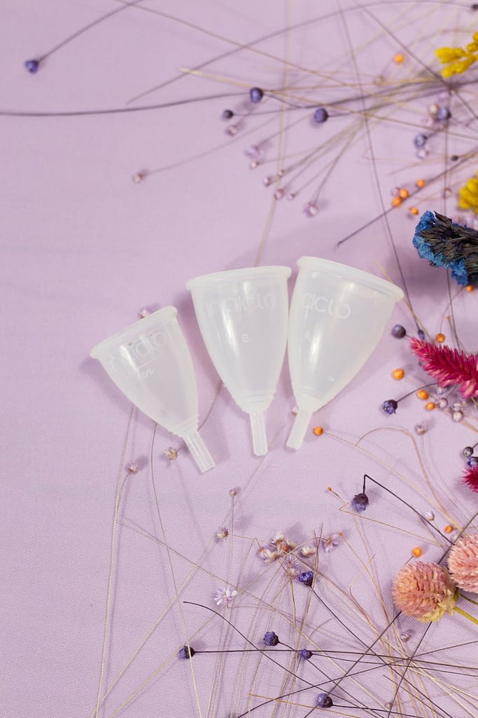 clear menstruation cups on purple background
