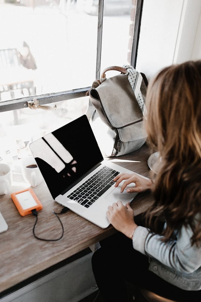 girl wearing grey long-sleeved shirt using MacBook Pro to declutter her digital files